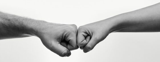 People giving each other knuckles to signify Outsourced IT Services VS In-House