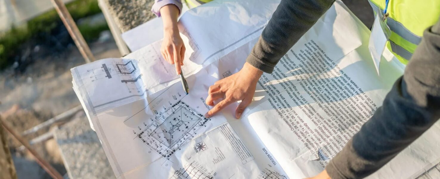 Two people reviewing a printed construction blueprint